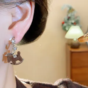 Close-up detail of a vintage brown flocked rocking horse earring with zircon stone accents