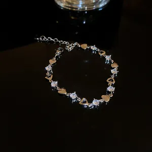 Macro detail of elegant silver heart charm bracelet featuring sparkling white cubic zirconia