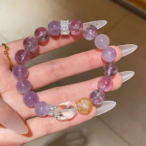 Detailed close-up view of a purple amethyst beaded bracelet with sparkling crystal charms