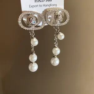 Close-up of luxury 18k gold plated zircon oval earrings with elegant pearl tassels