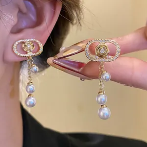 Detailed macro view of 18k gold plated pearl tassel clip-on earrings with CZ stones
