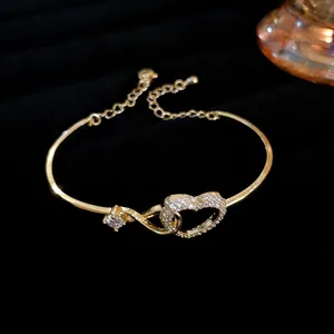 Detailed view of an elegant gold-tone bracelet featuring a sparkling zircon-encrusted heart charm