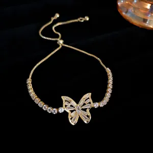Close-up of elegant gold butterfly bracelet with sparkling zircon stones on black background
