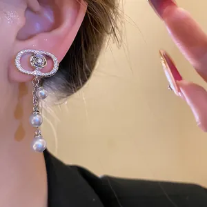 Detail view showing elegant oval earrings with zirconia flowers and cascading pearl tassels