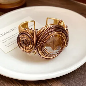 Vista dettagliata di un bracciale a polsino intrecciato a mano in stile boho con pietra ambrata.