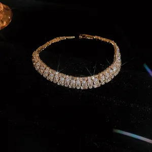 Macro detail of high-quality sparkling gold cubic zirconia bracelet on black velvet background