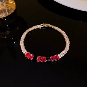 Macro shot of double-row zircon bracelet with rectangular red stones on a dark surface