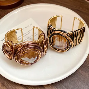 Primo piano di un bracciale a polsino boho intrecciato con pietra di vetro quadrata