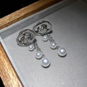 Detailed close-up view of elegant silver oval pearl tassel earrings with pave zircon settings