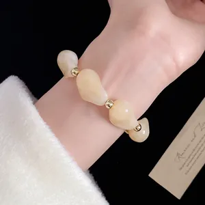 Vista dettagliata di un bracciale vintage in acrilico con perline irregolari e accenti d'oro