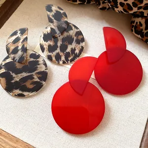 Close-up of retro leopard print and vibrant red acrylic geometric drop earrings for women.