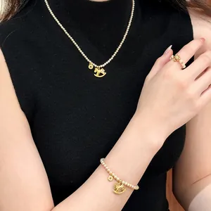 Elegante set di gioielli in perle con ciondoli a forma di cavallo a dondolo dorato