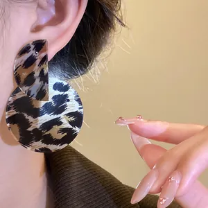 Elegant leopard print asymmetrical circular drop earrings showing a retro vintage style