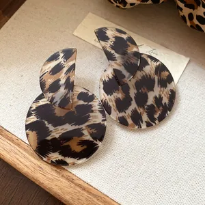 Detailed close-up view of vintage leopard print asymmetric circular acrylic dangle earrings