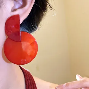 Close-up detail of vintage marbled red round drop earrings worn on an Asian ear.