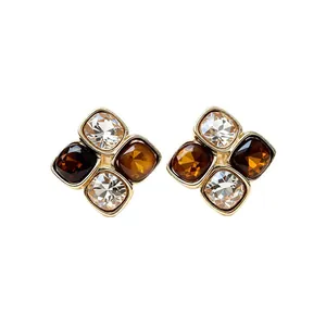 Elegant gold-plated square stud earrings featuring clear crystals and amber resin stones