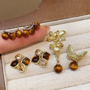 Macro view of vintage amber resin earrings with gold-tone floral and butterfly designs