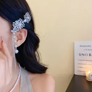Gros plan d'une pince à cheveux à pampilles en strass et fausses perles pour mariée élégante.