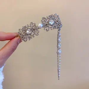 Détail d'une élégante barrette en strass et perles avec un long gland scintillant