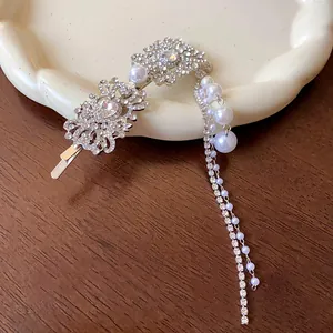Détail d'une pince à cheveux de luxe en strass avec d'élégants pompons en perles artificielles