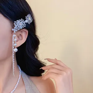 Détail d'une pince à cheveux de style ethnique avec strass et longs pompons en perles