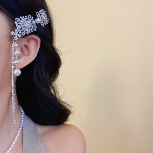 Gros plan d'une pince à cheveux chic en strass avec des glands de perles artificielles.