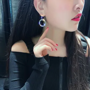 Gros plan de boucles d'oreilles géométriques à double cercle en strass