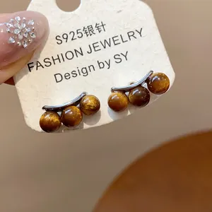 Macro view of vintage style arched earrings with gold glitter resin beads