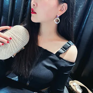 Gros plan d'un mannequin portant des boucles d'oreilles circulaires en cristal étincelant