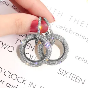 Gros plan de boucles d'oreilles créoles en argent serties de diamants pavés étincelants