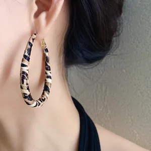 Primer plano de un pendiente de aro grande con estampado de leopardo de estilo retro Y2K