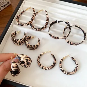 Primer plano de varios pendientes de aro y tipo C con estampado de leopardo para mujer