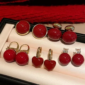 Close-up of assorted red retro earrings with gold accents in a jewelry display box