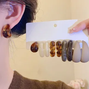 Detailed view of a retro acrylic C-shaped earring set with marbled resin and matte finish