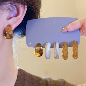 Close-up of vintage marbled acrylic earring set in Maillard brown on model and card
