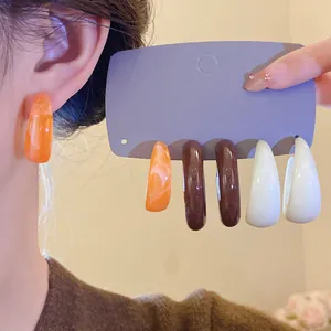 Detailed view of acrylic C-shaped earrings with vintage marble pattern in multiple colors