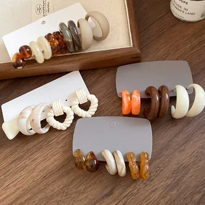 Detailed view of Maillard style acrylic C-shaped earring sets with marbled textures