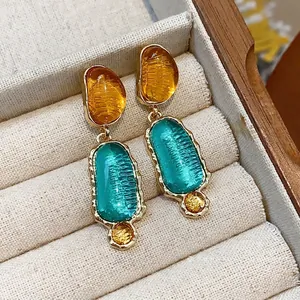 Elegant irregular oval drop earrings featuring orange and teal resin stones in gold finish