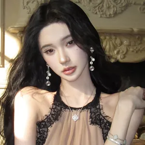 Model wearing elegant silver textured tassel earrings and a clover necklace in a luxury setting