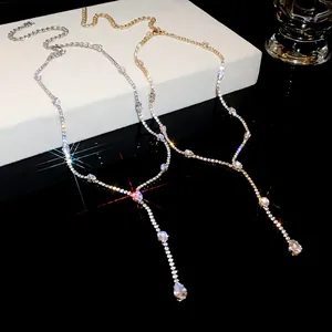 Close-up of gold and silver zircon tassel necklaces with sparkling waterdrop pendants.