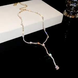 Close-up of sparkling silver teardrop zircon tassel necklace on white display box
