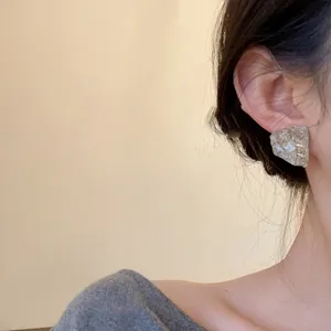 Elegant irregular silver needle resin stud earrings shown on a model's ear for daily style