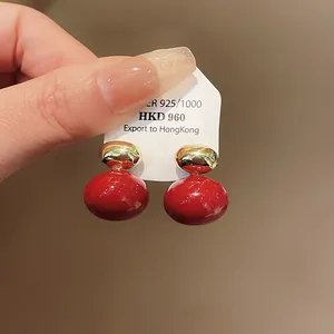 Detailed close-up view of elegant red and gold enamel stud earrings with S925 silver mark