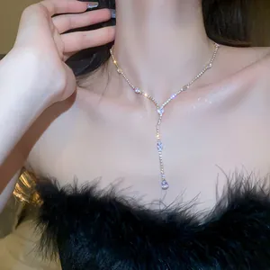 Detailed view of sparkling teardrop zirconia tassel necklace on a model's neck
