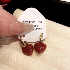 Close-up of vintage-style red heart-shaped earrings on a white jewelry card