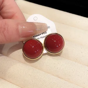 Detailed view of vintage red stud earrings with S925 silver needle and elegant gold trim