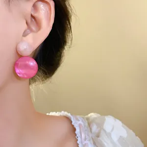 Detailed close-up showing elegant pink resin geometric drop earrings on an Asian model