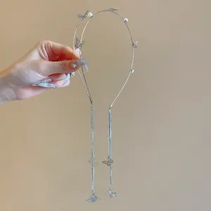 Close-up detail of elegant silver butterfly headband featuring pearls and long tassels