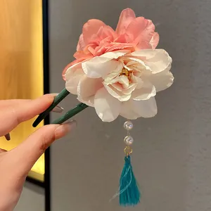 Nahaufnahme einer chinesischen U-Haarnadel mit Seidenblumen und Perlenquasten-Detail.