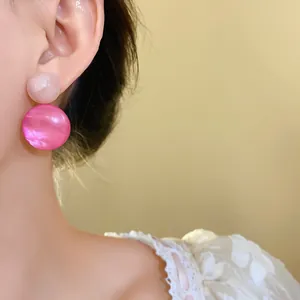 Detailed close-up showing pink resin geometric drop earrings worn on an Asian model ear